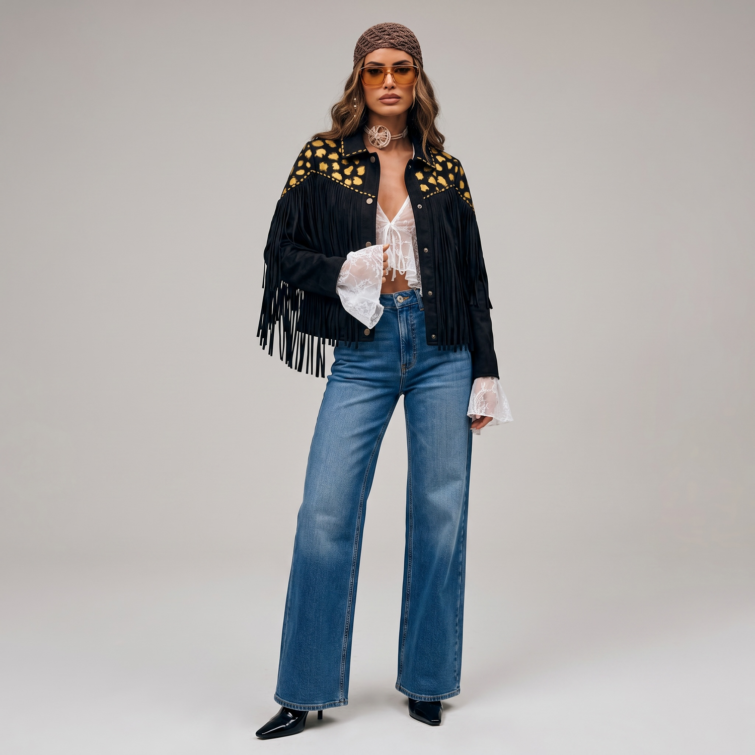 Modelo vistiendo prendas de la nueva colección de Paola Santos, con chaqueta de diseño, blusa de encaje y jean wide leg en una producción de moda sobre fondo neutro.
