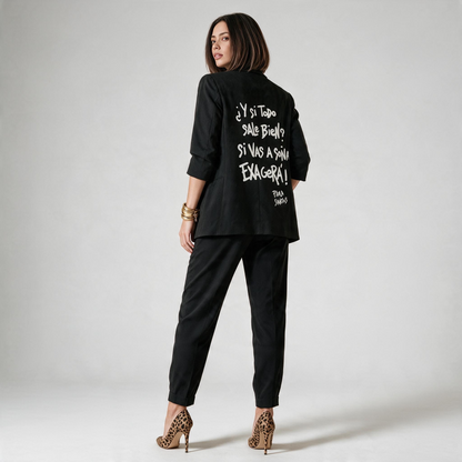Espalda de blazer negro con la frase pintada en blanco «Y si todo sale bien? Si vas a soñar, exagerá!».