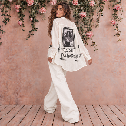 Camisa blanca de mujer, amplia y semitransparente, con intervención artística en la espalda y frase Estado civil escucho ofertas de Paola Santos.